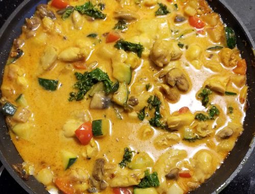 A picture of coconut curry chicken in a pan