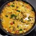 A picture of coconut curry chicken in a pan